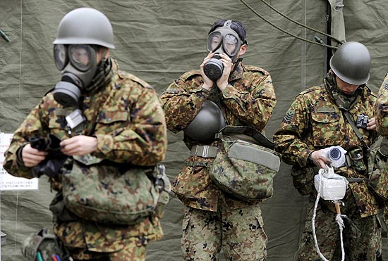 Soldados japoneses se equipam para lavar objetos contaminados com material radiativo em Fukushima