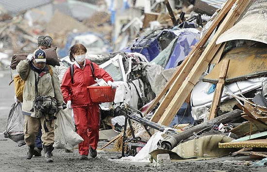 Sobreviventes do terremoto e tsunami de sexta-feira (11) vasculham por bens em Kamaishi