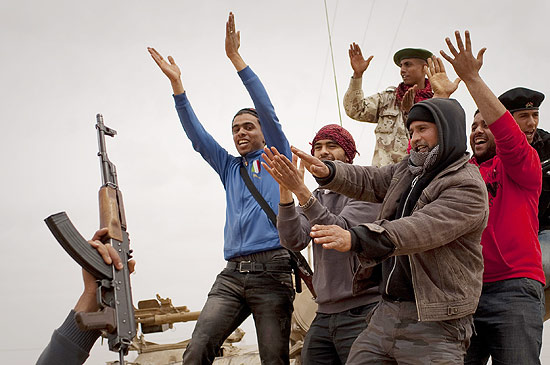 Rebeldes antigoverno, muitos deles armados, celebram na praa central de Benghazi, reduto da oposio