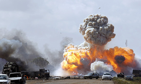 Veículos militares das forças de Gaddafi explodem em ataque aéreo internacional contra a Líbia