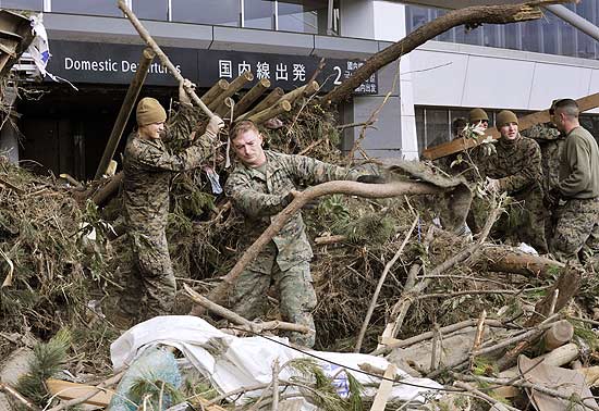 Marinheiros americanos ajudam a limpar destroos da entrada do aeroporto de Sendai, no Japo