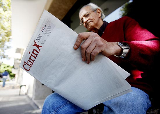 Leitor segura exemplar do "Clarín" desta segunda-feira; jornal deixou capa em branco em protesto ao governo argentino