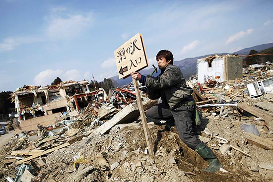 Homem coloca placa com o nome de seu bairro, destrudo em Rikuzentakata, na provncia de Iwate