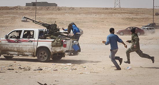 Rebeldes lbios fogem de disparos das fotras de Gaddafi nos arredores de Bin Jawad