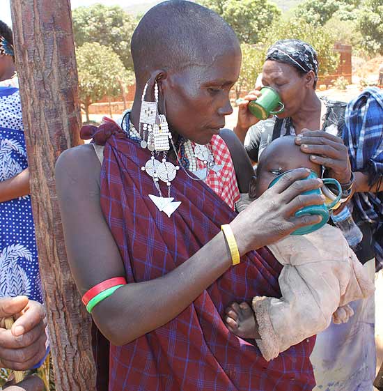 Mulher aguarda na fila por poção milagrosa do reverendo Ambilikile Babu Mwasapile, 76, em região remota