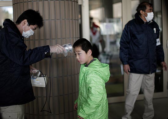 Mdico avalia menino num centro de triagem dos moradores retirados do entorno da usina nuclear de Fukushima