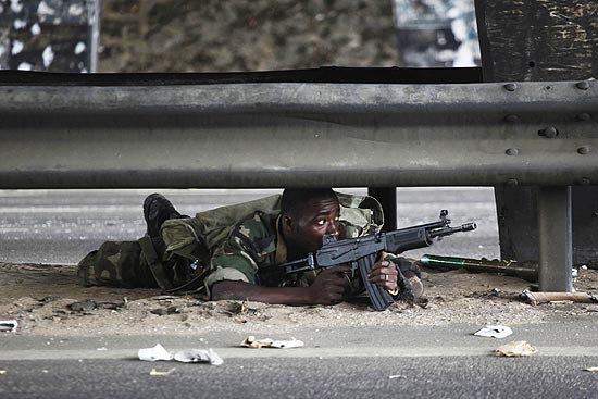 Soldado leal a Alassane Ouattara se posiciona em estrada durante batalha em Abdij