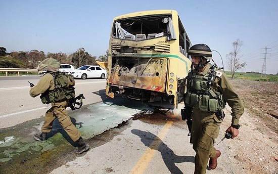 Soldados israelenses inspecionam nibus escolar atingido por foguete palestino; ao menos dois ficaram feridos