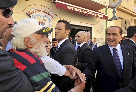O italiano Silvio Berlusconi cumprimenta morador da ilha de Lampedusa, ao sul da Itlia, em visita 