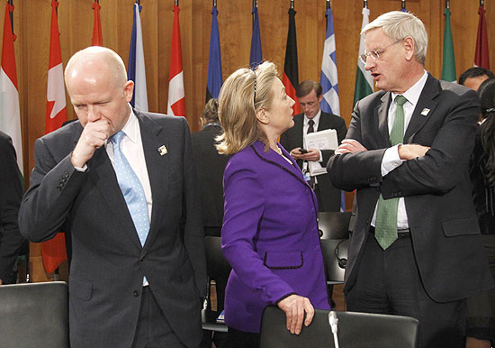 Americana Hillary Clinton conversa com sueco Carl Bildt, de costas para o britnico William Hague