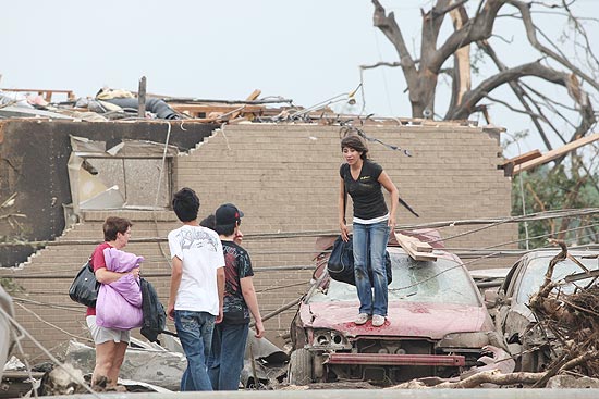 Moradores tentam recolher pertences após tornado destruir casas em Tuscaloosa, no Alabama 