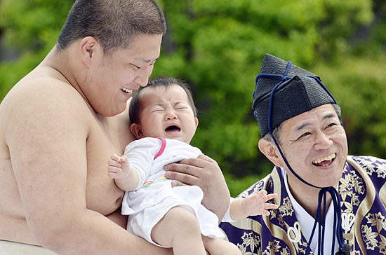 Beb chora no colo de lutador de sum em competio em Tquio; evento  oportunidade de orar pela sade do beb