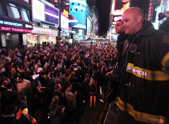Integrantes do corpo de bombeiros comemoram com a população a prisão de Bin Laden na Times Square, em Nova York