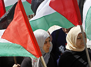 Mulheres palestinas seguram bandeiras durante protesto contra fechamento da faixa de Gaza