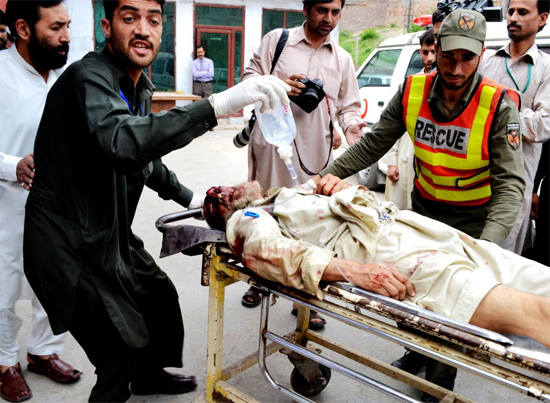Paramédicos atendem vítima de atentado duplo a centro de treinamento militar no Paquistão