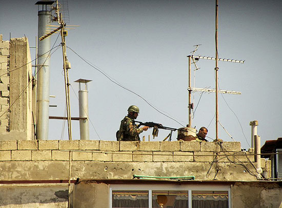 Foto tirada com celular mostra soldados sírios no topo de prédio em local não-divulgado na Síria