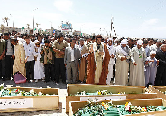 Religioso comanda cerimônias fúnebres dos civis mortos no ataque da aliança militar ocidental à cidade de Brega