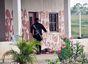 Policial em frente a casa com frases escritas em sangue; Los Zetas teriam matado 28 agricultores no local