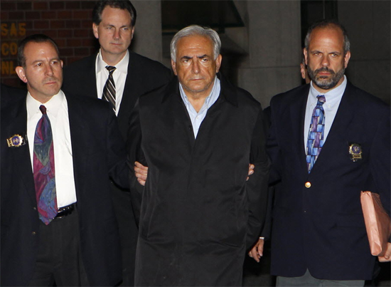 Dominique Strauss-Kahn (centro), chefe do FMI, deixa delegacia de polícia de Nova York na noite deste domingo