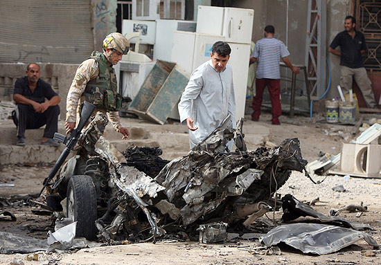 Tropas iraquianas inspecionam o local de um carro-bomba em um bairro xiita em Bagd, no Iraque