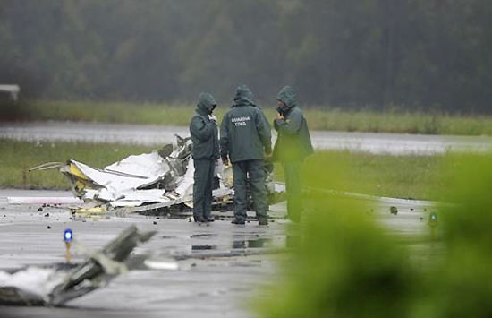 Guardas civis ao lado de escombro de uma das aeronaves acidentadas; choque de aviões mata 4 na Espanha