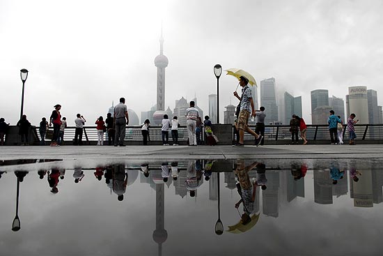 Pessoas caminham pelo rio Huangpu, depois de dois dias de intensas chuvas em Shanghai