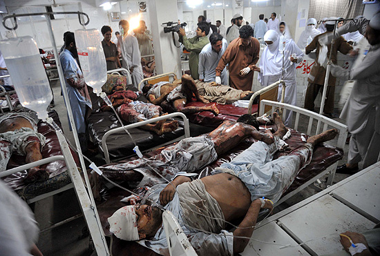 Paramdicos paquistaneses atendem vtimas de exploses em de Peshawar; cerca de 90 ficaram feridos