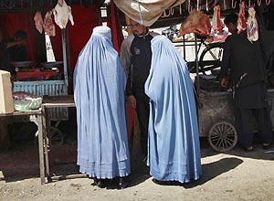 Mulheres afegãs conversam com um vendedor no centro de Cabul, capital do Afeganistão