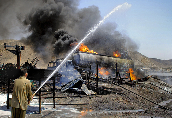 Bombeiro paquistans apaga chamas de caminho-tanque incendiado por militantes em Quetta