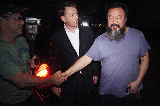 Ativista e artista Ai Weiwei ( dir.) cumprimenta jornalistas estrangeiros ao chegar em sua casa, em Pequim