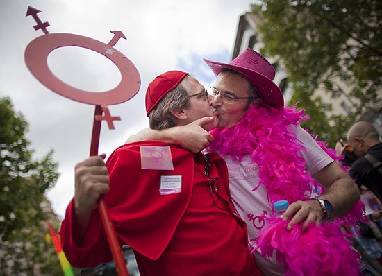 Participantes fantasiados se beijam durante Parada do Orgulho Gay em Paris