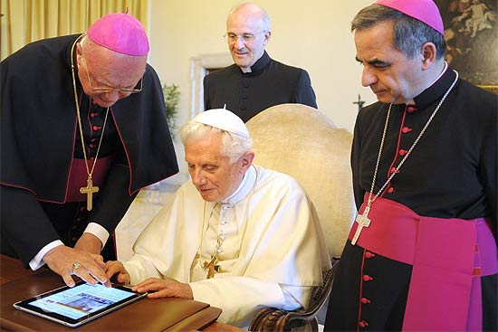 Bento 16 usa um tablet para escrever seu primeiro tweet sobre o lançamento do portal de notícias do Vaticano