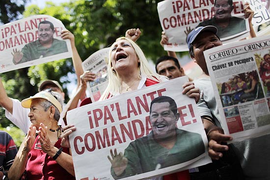Partidários de Chávez seguram jornais com imagens do presidente nas ruas de Caracas
