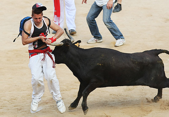 Participante leva chifrada em uma das corridas de touros do festival de So Firmino, na Espanha