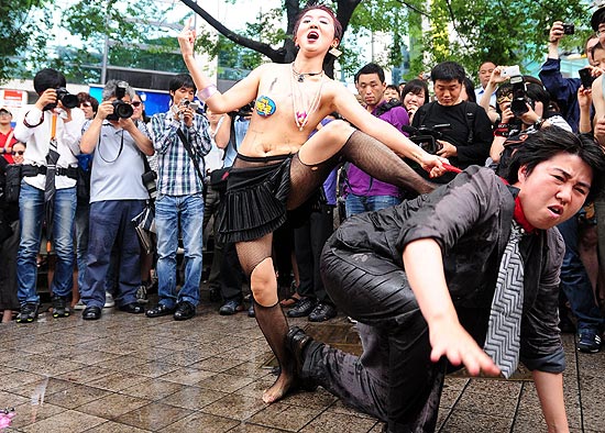 Sul-coreana faz performance durante a Marcha das Vadias, movimento global contra violência sexual