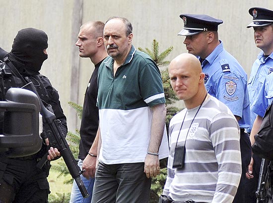Agentes da polcia srvia escoltam o ex-lder Goran Hadzic (com camisa verde e branco)
