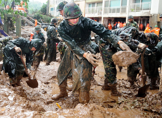 Soldados do Exército sul-coreano ajudam nos trabalhos de remoção da lama acumulada nas ruas de Seul