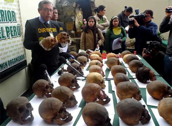 Policial peruano mostra crânios humanos que estavam em poder de um curandeiro que foi detido no centro de Lima