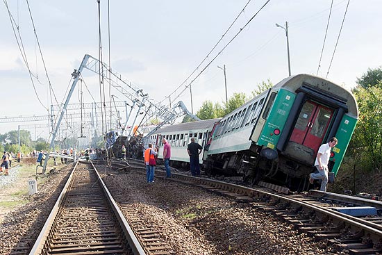 Pessoas caminham perto de trem descarrilado perto de Baby, no centro da Polônia