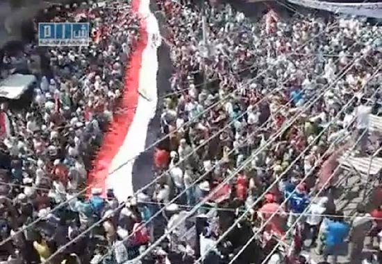 Imagem de TV mostra srios carregando bandeira nacional em protesto pela sada do ditador Bashar Assad
