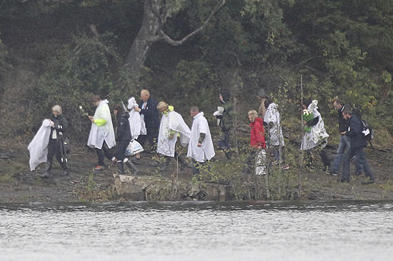 Pessoas chegam à ilha norueguesa de Utoeya reaberta para os familiares das vítimas após os ataques 