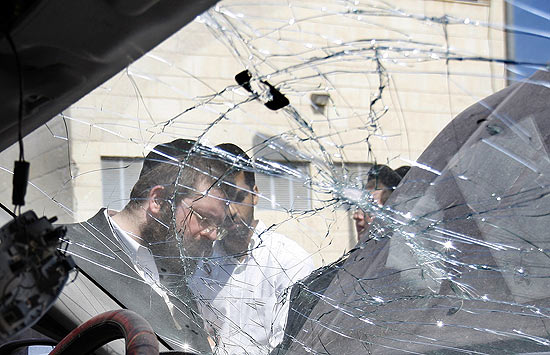 Judeus podem ser vistos por janela de carro quebrada por foguete lançado de Gaza em Ashdod