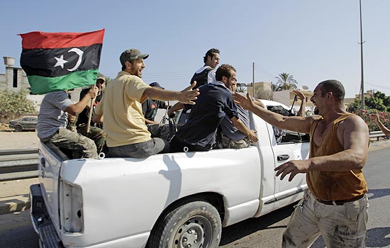 Moradores cumprimentam rebeldes nos arredores de Trípoli; Obama diz que Gaddafi precisa "deixar explicitamente" o poder