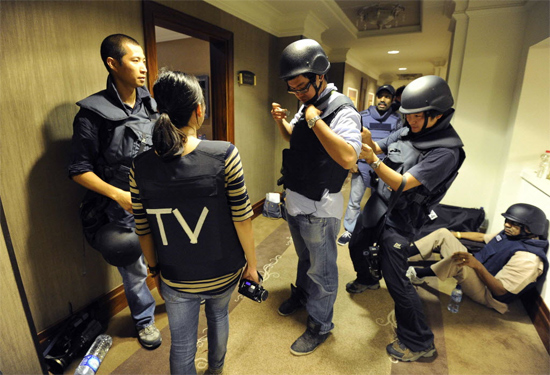 Jornalistas vestem coletes à prova de balas no hotel Rixos, em Trípoli