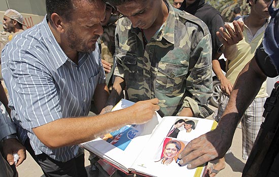 Rebeldes vasculham album de fotografias encontrado no interior do complexo residencial do ditador Muammar Gaddafi