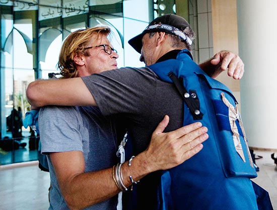 O fotógrafo americano Dario Lopez (dir.), da agência Associated Press, abraça um amigo após serem libertados do Hotel Rixos