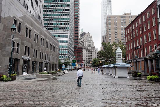 Homem caminha em rua praticamente vazia de calçadão nova-iorquino
