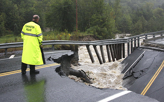 Policial observa ponte que caiu por conta da alta de um rio no Estado de Vermont, atingido pelo furacão Irene