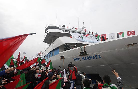 Pessoas agitam bandeiras turcas e palestinas no retorno do Mavi Marmara a Istambul após incidente com Israel