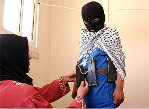 Em um dos sites, uma imagem de uma mão colocando um cinto de explosivos em seu filho, incentivando o uso de crianças em ataques